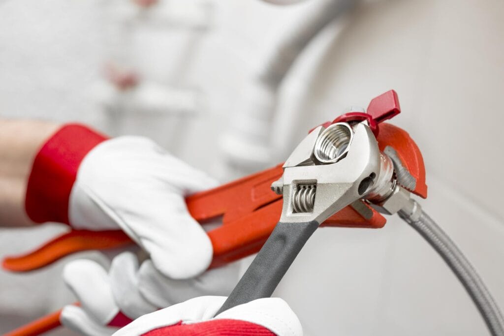 Plumber holding pipe wrenches for an emergency repair in El Cajon